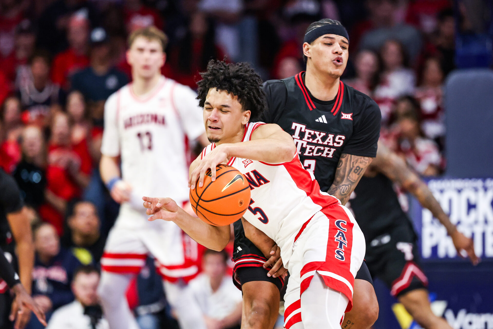 Arizona Wildcats guard Brayden Burries (5) dribbles the ball while Texas Tech Red Raiders forward LeJuan Watts (3) attempts to block him during the first half of the game at McKale Memorial Center.